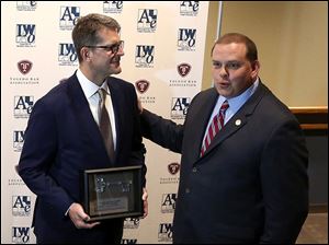 University of Michigan's Jim Harbaugh, left, is presented the key to the city by Mayor Wade Kapszukiewicz on May 10.