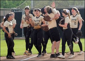 Perrysburg head coach Ryan Demars hugs outfielder Abby Seely after she made a big play against Whitmer during a Division I softball district championship game Thursday.