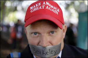 Daryl Tempesta tapes a sign over his mouth in protest during a demonstration on April 27, 2017, in Berkeley, Calif.