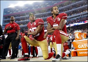 In this 2016 file photo, San Francisco 49ers safety Eric Reid (35) and quarterback Colin Kaepernick (7) kneel during the national anthem before an NFL football game.