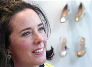 In this May 13, 2004 file photo, designer Kate Spade poses with shoes from her next collection in New York. Law enforcement officials say Tuesday, June 5, 2018, that New York fashion designer Kate Spade has been found dead in her apartment in an apparent suicide. 