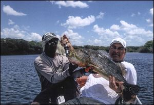 Daryl Powell, a grain farmer from Republic, fished above the Arctic Circle and also made three trips to the Amazon River. Powell, pictured with his Brazilian guide, holds a peacock bass he caught on the Amazon. Powell, who passed away in 2013 at the age of 77, had a lifelong dream of hunting in Africa, but he died before making the trip. 