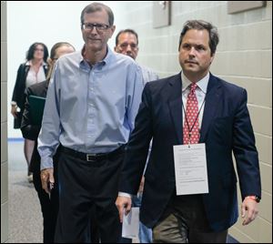 Newly elected Lucas County Republican Chairman Mark Wagoner, right, walks in front of former party chairman Jon Stainbrook before the party’s recent central committee reorganizational meeting.