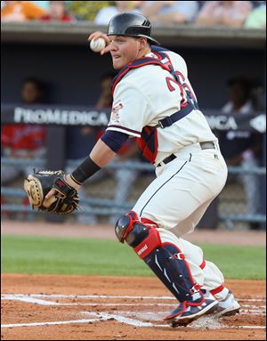 Toledo Mud Hens catcher Kade Scivicque gets set to throw to third base during Friday's game against the Louisville Bats at Fifth Third Field in downtown Toledo.