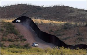  This Oct. 2, 2012 file photo shows U.S. Border Patrol agents patrolling the border fence near Naco, Ariz.