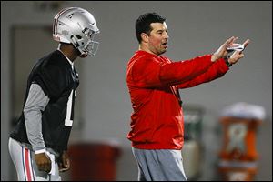 Ohio State quarterbacks coach Ryan Day, right, instructs quarterback J.T. Barrett last year. Day is OSU's acting coach for the first three games.