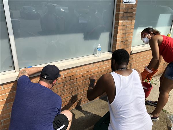 Community comes out for cleanup after racial slurs painted on closed bar