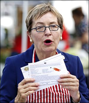 U.S. Rep. Marcy Kaptur shows some recipes that can be made with fresh produce during an event to highlight the Senior Farmers Market Nutrition Program in Toledo.