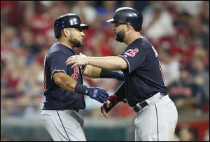 Cleveland Indians' Melky Cabrera, left, gets a hug from Yonder Alonso following Cabrera's a two-run home run off Cincinnati Reds relief pitcher Cody Reed.