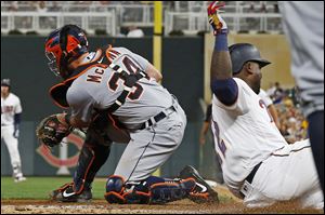 Minnesota Twins' Miguel Sano, right, beats the throw to Detroit Tigers catcher James McCann to score on a two-run single by Mitch Garver during the sixth inning.