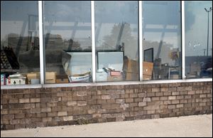 Items are stacked up near a front window adjacent to the front entrance of a vacant store, which was formerly a Food Town Market, on 5860 Lewis Avenue in Toledo on August 15.