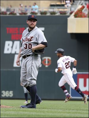 Detroit Tigers pitcher Alex Wilson, left, gives up a solo home run to break the tie by Minnesota Twins' Eddie Rosario, right, in the eighth inning.