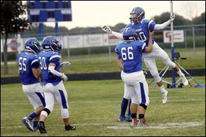 Stryker's Noah Huffman hoists up teammate Max Wonders (80) as they get pumped up before their home season football opener Friday.