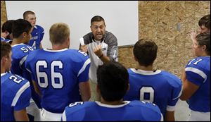 Stryker head coach Justin Sonnenberg, center, delivers his speech as his team gets set for the high school's first game since 1931 on Friday.