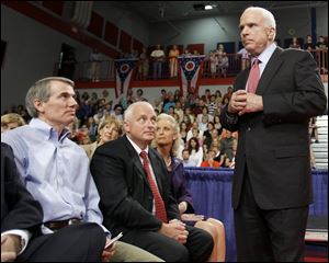 Former White House Budget Director Rob Portman, left seated, looks up at Republican presidential candidate, Sen. John McCain as McCain makes a campaign stop in Portsmouth, Ohio in 2008. Mr. Portman is now a U.S. senator.
