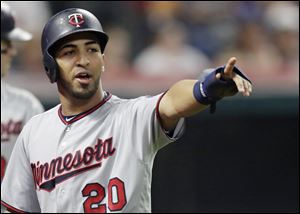 Minnesota Twins' Eddie Rosario points to Robbie Grossman after Grossman hit a two-run single in the seventh inning off of Cody Allen of the Cleveland Indians.