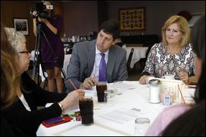 Democratic nominee for Attorney General Steve Dettelbach, center, discusses human trafficking during a roundtable his campaign called with local officials Thursday at Michael's Bar and Grill in Toledo. Also pictured are attorney Catherine Hoolahan, left, and state Rep. Teresa Fedor (D., Toledo), right.