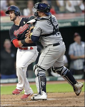 Cleveland Indians' Yan Gomes, left, is tagged out at home plate by Tampa Bay Rays catcher Jesus Sucre.