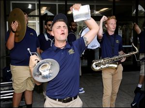 Band member Ethan Jessing, a sophomore, of Delta, front, chants while playing the UT fight song during a pep rally around Centennial Mall on the University of Toledo campus.