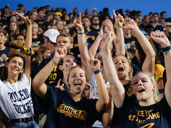 Univer­sity of Toledo fans cheer on the Rock­ets dur­ing a foot­ball game in the Glass Bowl. Go Rock­ets!