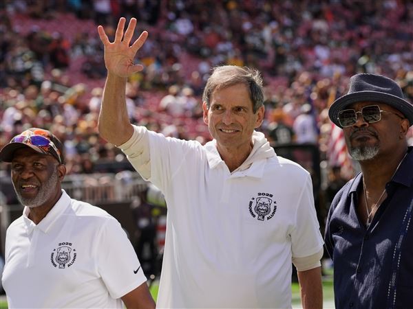 Former Cleveland Browns quarterback Bernie Kosar waves during a Browns' Alumni event on Sept. 21 in Cleveland.
