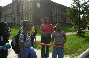 Leigh Miller (center) arrives to take her daughter, student crossing guard Kenia Quinn, home from Warren Elementary School. A parent whose child has attended Warren since it reopened in near-downtown Toledo in 1995, Ms. Miller says the school's curriculum should reflect the skills tested on Ohio proficiency tests, but it doesn't.