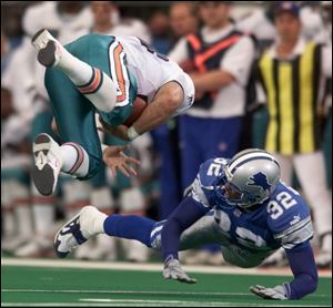 Dophins fullback Ron Konrad pulls in a pass during the first quarter in front of Lions cornerback Bryant Westbrook.