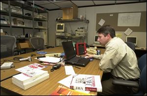 Brad Asher works in a lab at Pilkington North America, which has lengthened its PC leases.