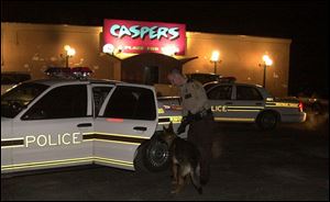 A drug-sniffing police dog is prepared for its role as police officers move in for the raid.