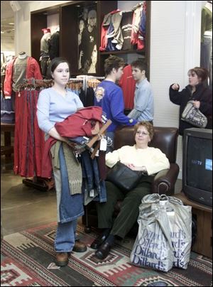 Toledoans Allyson Corbett and her mom, Mary Corbett, seated, await a dressing room at Franklin Park Mall.