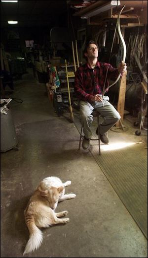 Lukas Novotny of Grand Rapids tests one of his hand-crafted bows. Novotny will take part in the European hunting and fishing show in June in France.