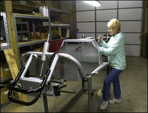 Donna Meyer tightens a component on a frame for one of the hand-assembled customized carts.