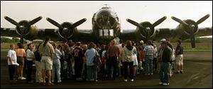 Fifth graders on a visit to the Seneca County Airport are dwarfed by the renovated B-17 Flying Fortress.