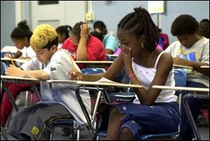 Matias Ponce, 12, and Tamika Draper, 12, take a placement test at the University of Toledo for Gear Up, which focuses on math and science skills.