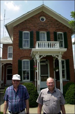 Daryl, left, and Dale Bridenbaugh grew up in the farm house behind them. Daryl lives there now, Dale down the road.