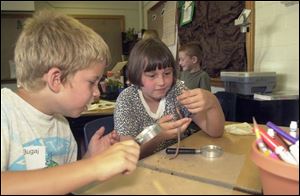 `I think he likes me,' says Holly Davis as she and Tyler Bugaj, both 8, study a nightcrawler at St. Pius X School in a class designated as a model for integrated thematic instruction.