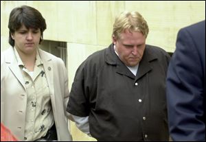 CTY August 2, 2001  Jimmie Woodland, of Fostoria,  leaves the Federal Courthouse in Toledo, Ohio under guard following his arraignment for the theft and interstate transport of the vehicle of Fred Smith of the Dayton area. Smith had been murdered previous to the theft.  [Person on left is unidentified. ] Jetta Fraser/Blade