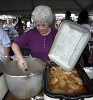 Pat Ziegler scoops out stuffed cabbages. Food, music, and neighborhood cohesiveness are the bywords of the annual East Toledo celebration.