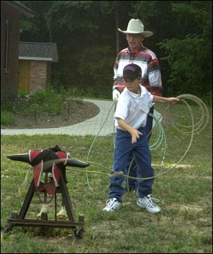 GOTCHA: Cowboy Bob Thibert teaches Camron Wysocki how to rope at the Barbecue Pavilion at Wildwood.