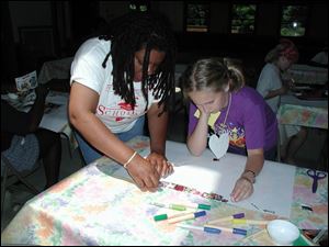 Artist Jenita Landrum-Bittles, left, works with Alisha Vasquez on her project, at right, which will be part of the Common Threads Exhibit at Bluffton College. 