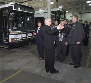 David Burnham, maintenance foreman for the Toledo Area Regional Transit Authority, ex- plains the workings of the bus garage to Transit Windsor representatives during their tour.