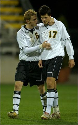 Chris Gree (5) consoles Perrysburg teammate Kevin King after King was unable to score a goal in the shootout. King did score a goal in regulation.