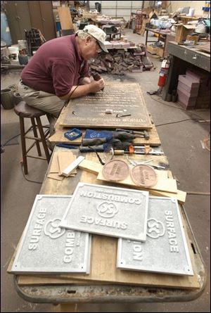 Glenn Nelson works on a bronze marker in his shop in Napoleon, where he has eight employees.