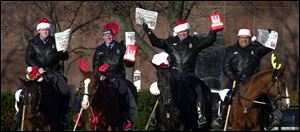 Members of the Toledo police department's mounted patrol — from left, Rob Summers on Duke, Dave O'Brien on Blue, Mike McGee on Harley, and Abe Diaz on Bugsy — are ready to ride for the Old Newsboys Goodfellow Association's 72nd annual newspaper sale tomorrow. 