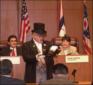 Michael Lieber, Sylvania's town crier, reads a proclamation declaring a new year of politics at the outset of the Lucas County commissioners' meeting.