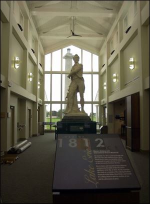 A 20-foot statue of Commodore Perry, lent by the city of Perrysburg, has the place of honor in the three-story atrium, which frames the monument.