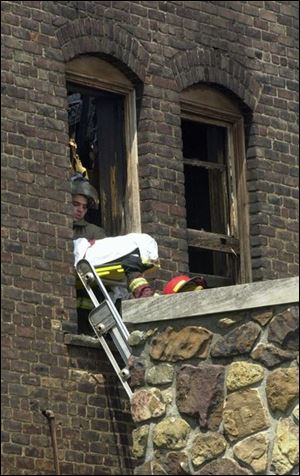 Firefighters remove the body of one of the victims. It took eight fire departments to bring the fire under control.