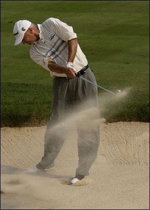 Don Pooley hits out of a fairway trap on No. 18. His shot was 30 yards short of the green, but he managed to save par.