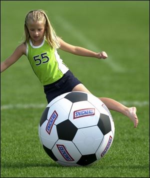 Molly Berrier, 9, came from St. Louis to watch players from her hometown play. She practices with an oversized ball.