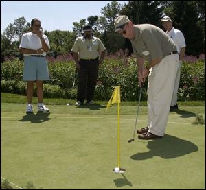 PUTT: Jeff Peterson's putt lips out as pro Dina Ammaccapane, Imran Andrabi, and Dennis LeGolvan watch at Mercy Health Partners Putting Pro-Am. 